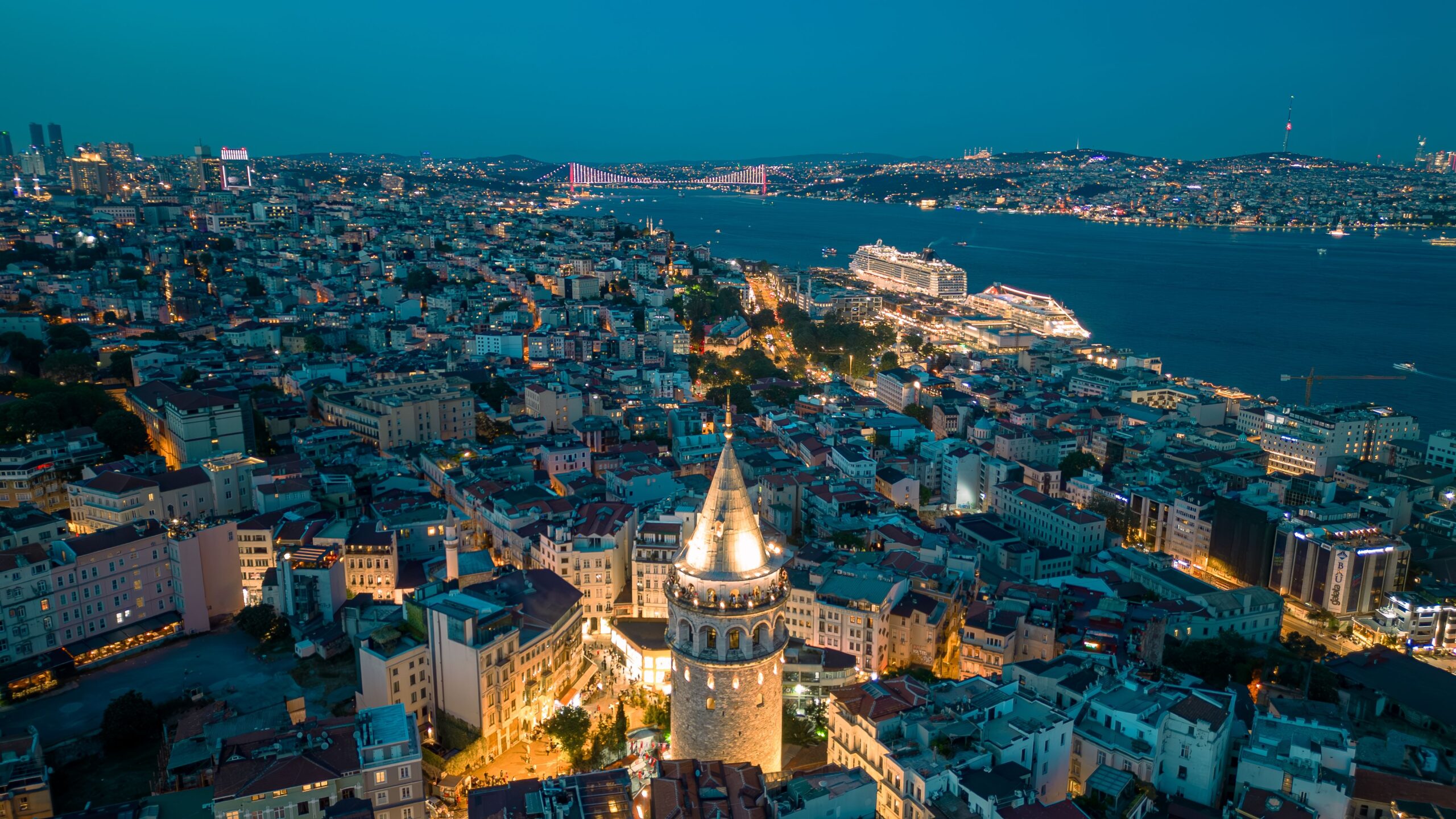 Home Stunning aerial view of Galata Tower with illuminated Istanbul skyline at night.